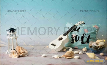 GUITAR SITS ON A BEACH WITH THE OCEAN PRINTED BACKDROP